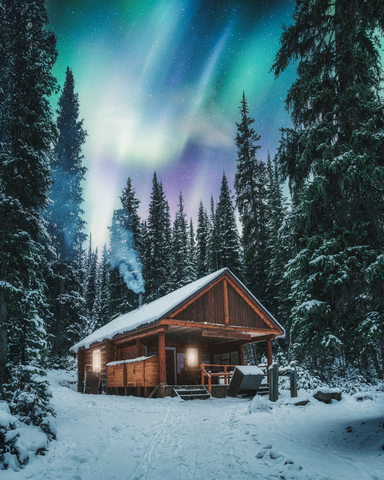 Aurora over snowy cabin